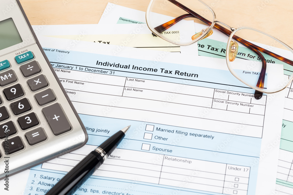 Tax form with calculator, pen, and glasses; document are mock-up Tax form with calculator, pen, and glasses; document are mock-up
