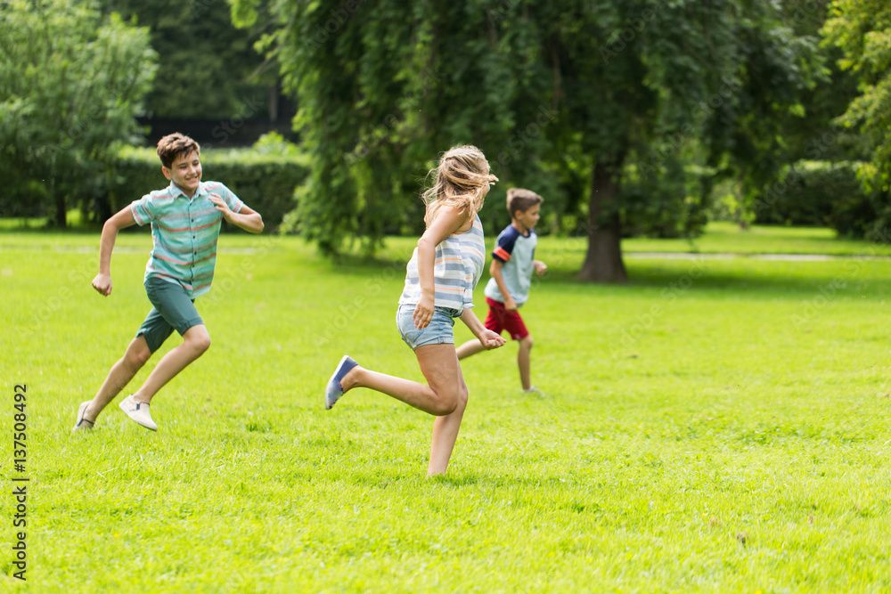 group of happy kids or friends playing outdoors group of happy kids or friends playing outdoors