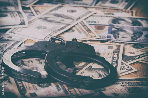 Dollars and handcuffs. Financial crime, illegal activity