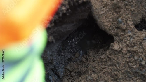 Wallpaper Mural Water dripping in dirt puddle. Worker in hard hat stand next to it. Slowmotion, close up Torontodigital.ca