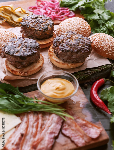 Ingredients for a tasty and juicy burger home in a rustic style with a big chop of beef