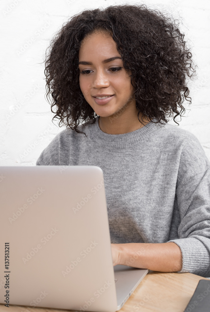 Young woman using laptop computer while sitting at desk, working from home Young woman using laptop computer while sitting at desk, working from home