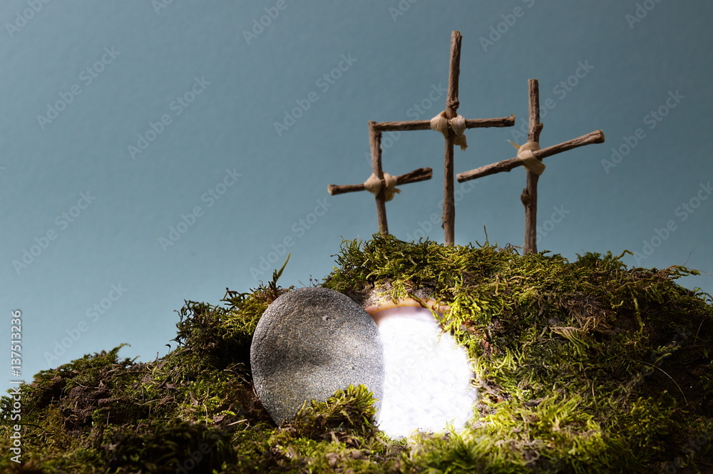 Obraz premium resurrection garden as easter decoration with a stone near the empty tomb filled with blinding light and three crosses on a hill above