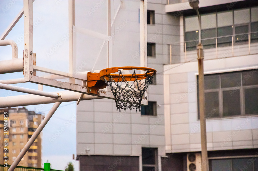 A basketball hoop without a ball inside on the background of the city