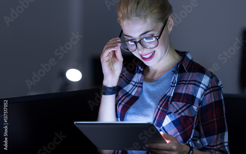 Charismatic IT girl testing gadgets in the dark lighted room