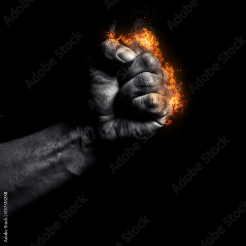 Burning man's clenched fist on a black background