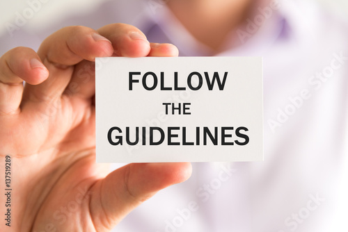 Obraz na płótnie Businessman holding FOLLOW THE GUIDELINES card w salonie