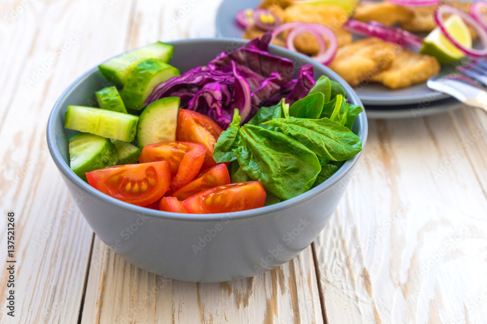 Crispy fried fish tilapia and green vegetable salad