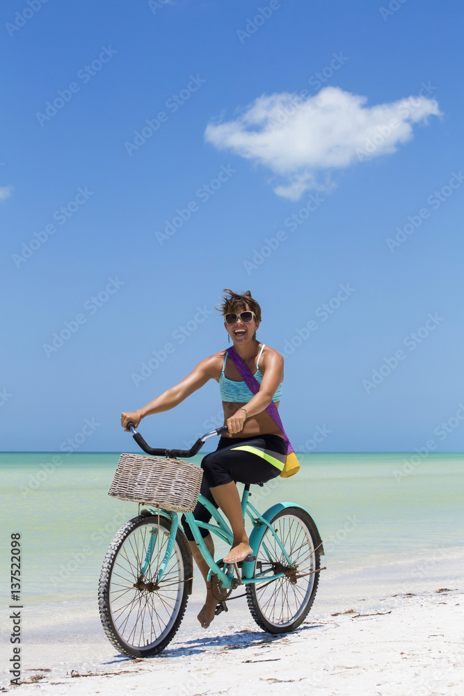 Woman rides bike to yoga at the beach - obrazy, fototapety, plakaty 