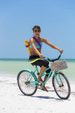 Woman riding bike to yoga at the beach