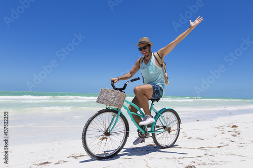 Tourist riding a bike on the beach.