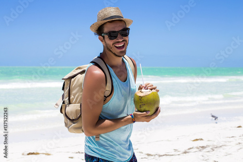 Tourist having a coconut drink on the beach