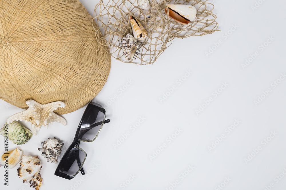 Fototapeta premium holiday setting with hat, sunglasses and seashells on white background