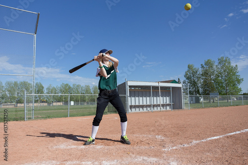 Wall Mural young girl swinging at a baseball