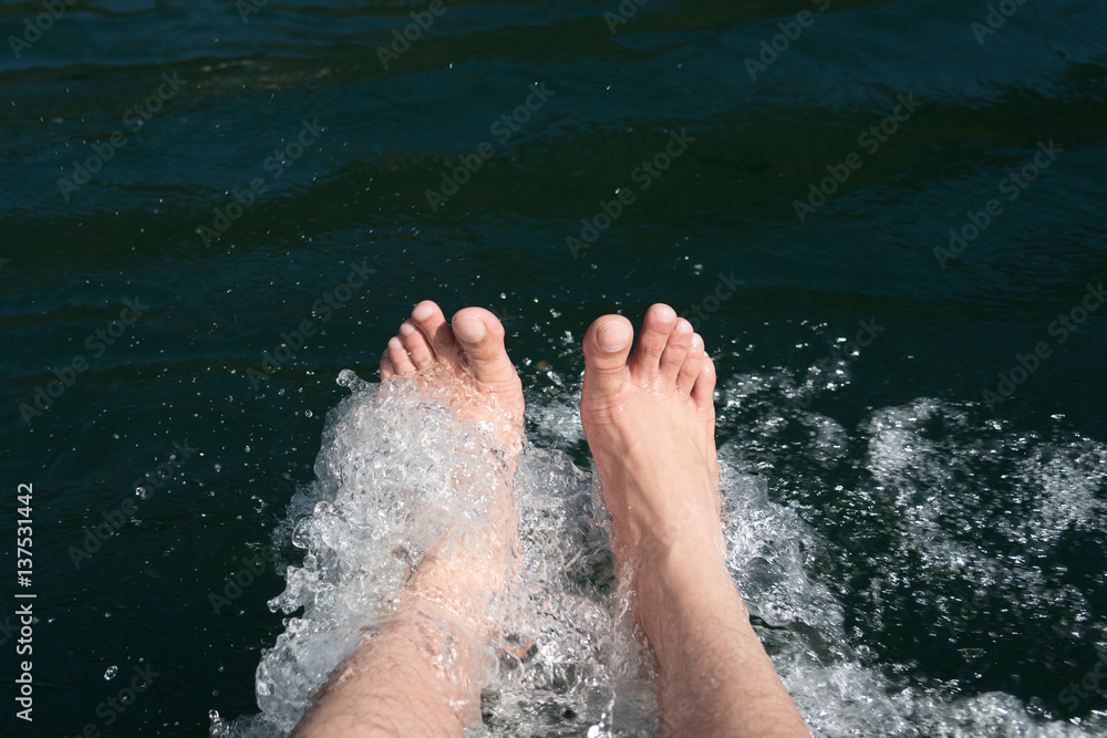 Dipping feet in water off a dock on a hot summer day.