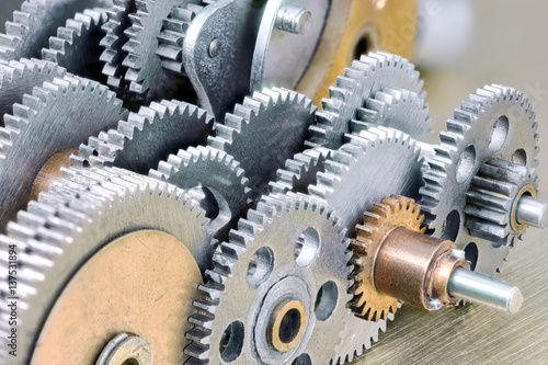 set of steel mechanical gears on industrial brass background closeup