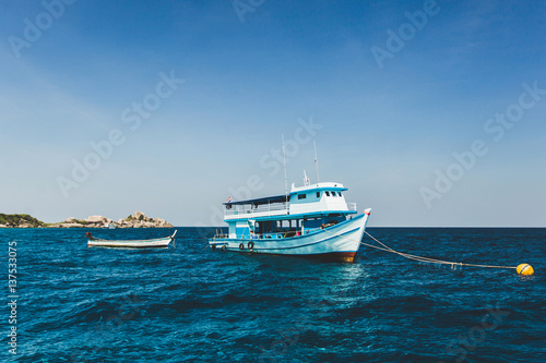 Tourist boat near island shore with turquoise clear transparent water. Idyllic view of Similan Islands