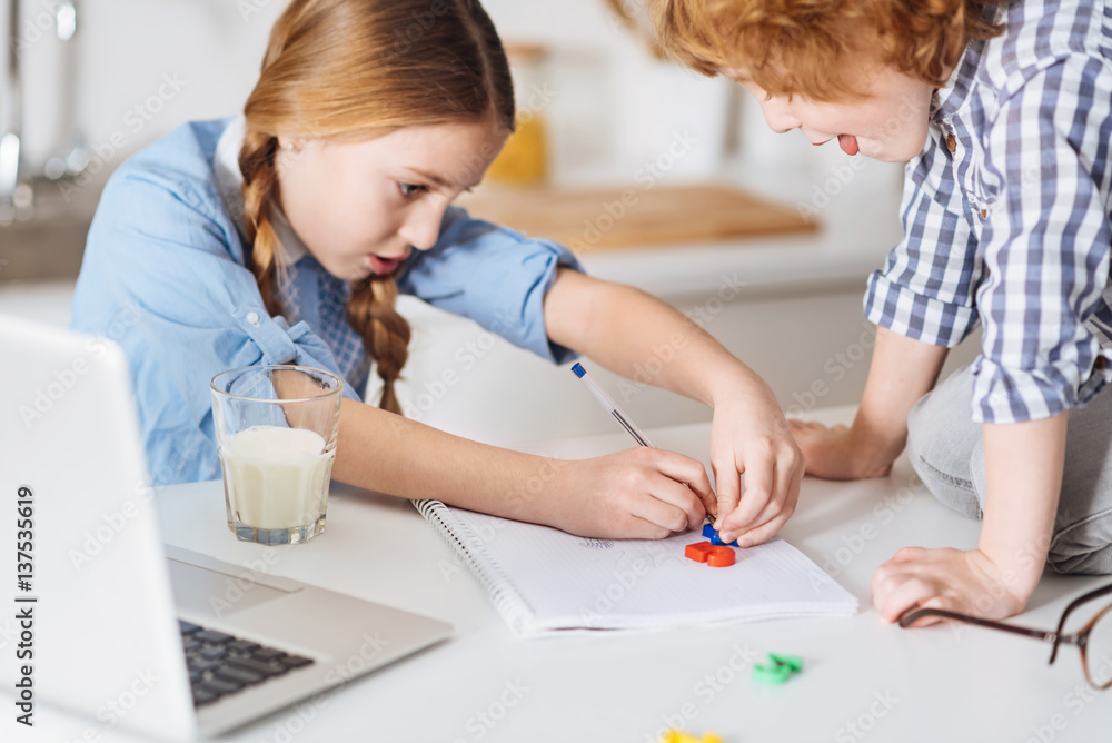 Enthusiastic clever child outlining the number with a pen Enthusiastic clever child outlining the number with a pen