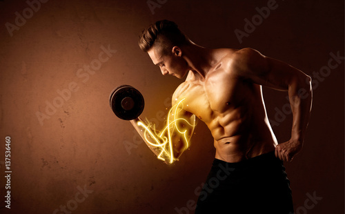 Muscular body builder lifting weight with energy lights on biceps