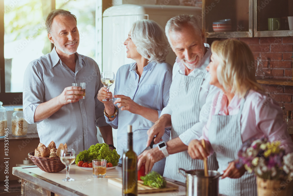 Positive aged friends cooking together Positive aged friends cooking together