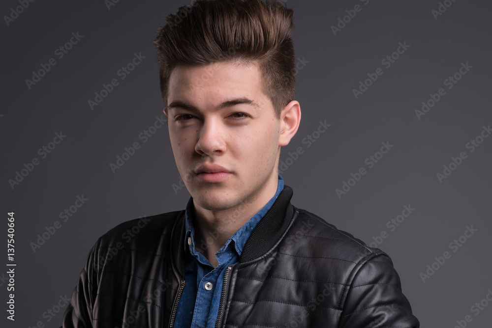 Casual young man in black jacket, jeans and boots on black background. Studio shoot. Casual young man in black jacket, jeans and boots on black background. Studio shoot.