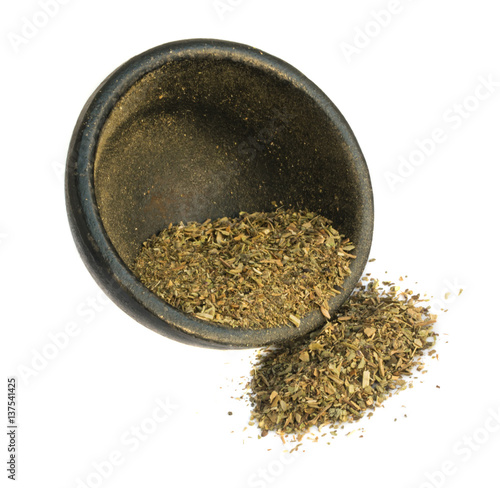 Heap of Dried Basil Flakes in Black Round Bowl Isolated