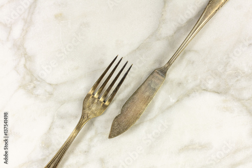 Vintage fork and knife on white marble with copyspace