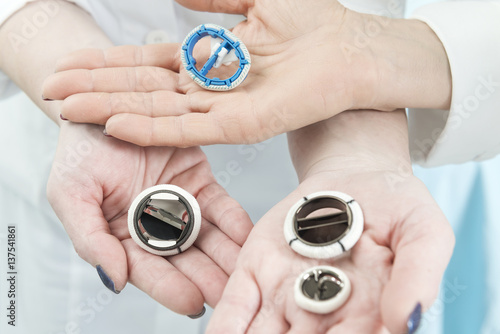 Assorted mechanical heart valve prosthesis presented by doctors hands