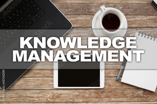 Tablet on desktop with knowledge management text.