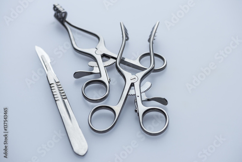 Bild auf Leinwand Two retractors and scalpel on a blue background