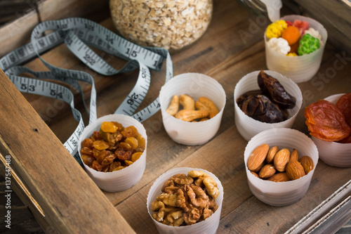Nuts and dried fruits in a box on a wooden table in rustic style