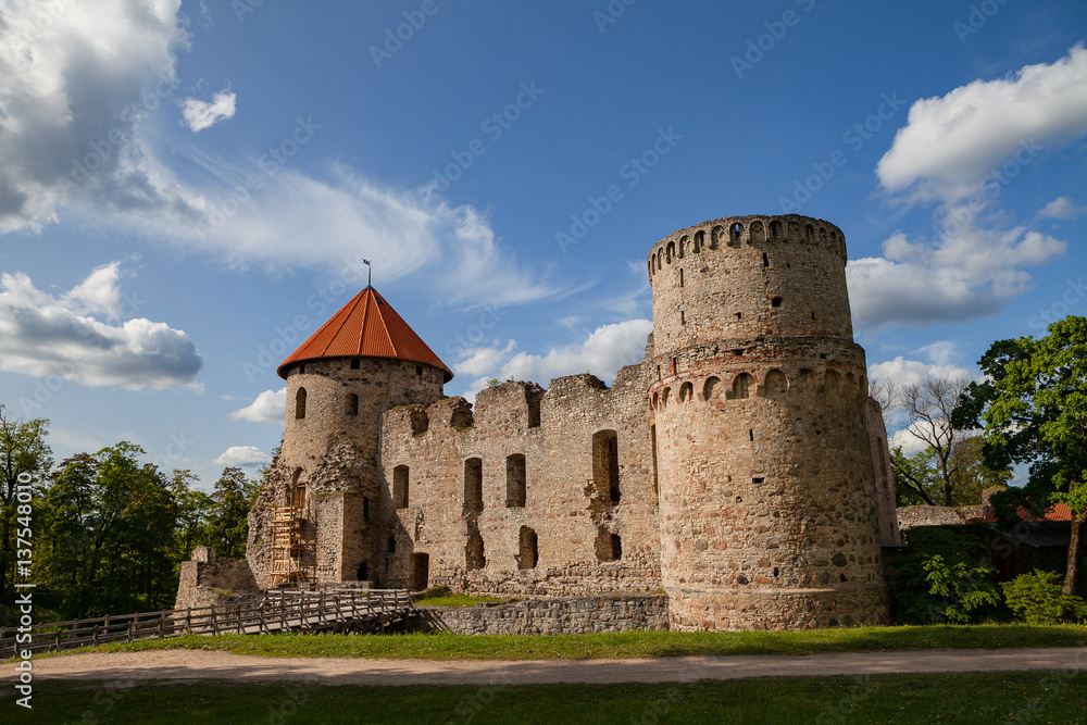 View of beautiful ruins of ancient Livonian castle in old town of Cesis, Latvia. Greenery and summer daytime.