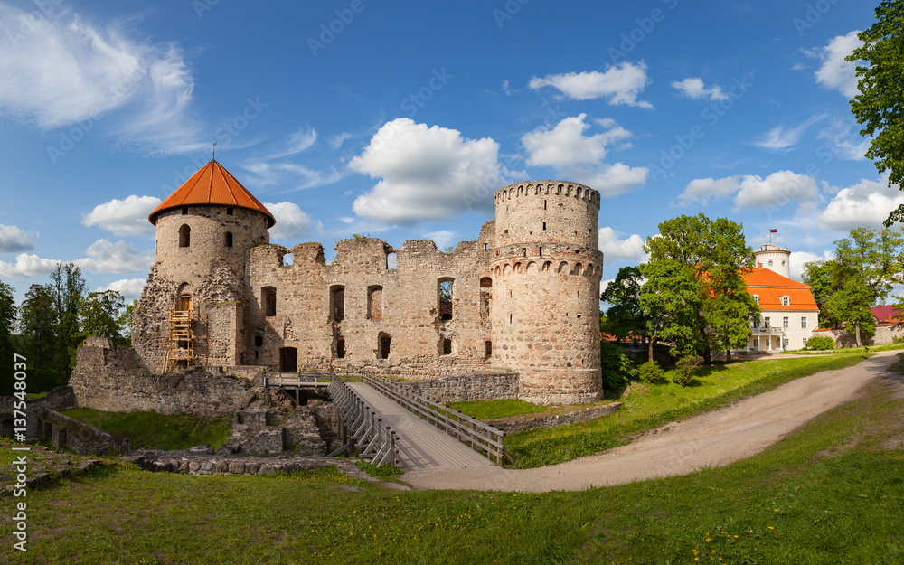 View of beautiful ruins of ancient Livonian castle in old town of Cesis, Latvia. Greenery and summer daytime.