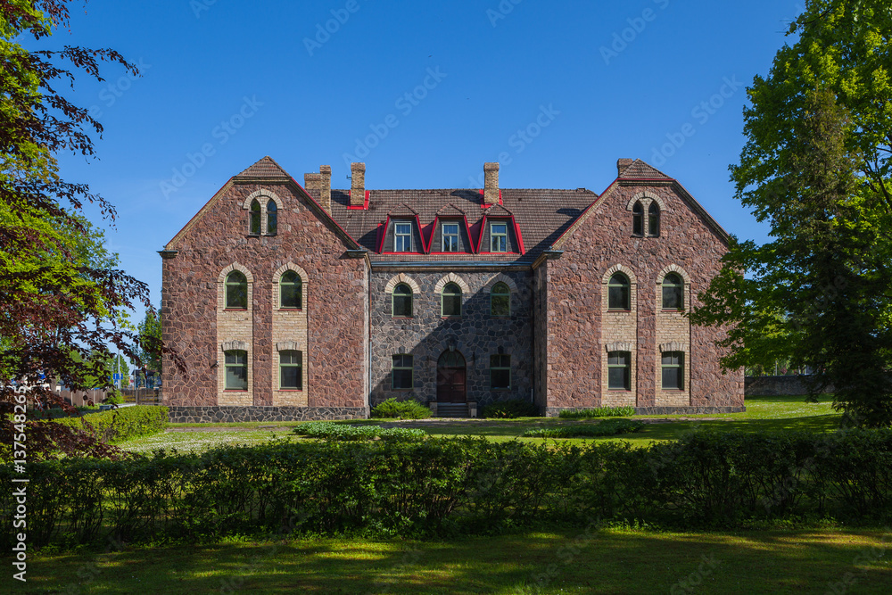 Old stone trafitional building in Cesis, Latvia and green park below