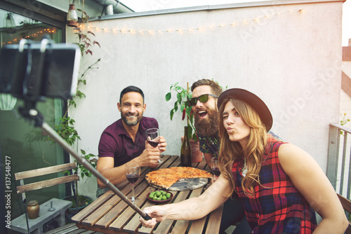Konstfotografi Friends at table posing for phone on selfie stick