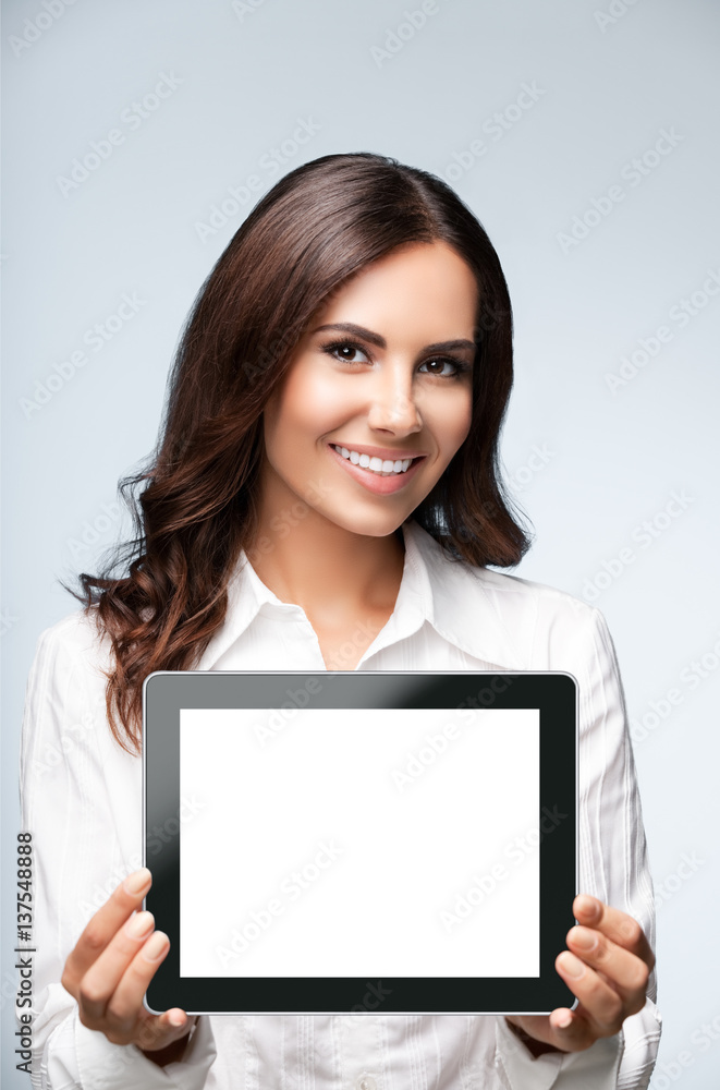Businesswoman showing blank tablet pc, on grey Businesswoman showing blank tablet pc, on grey