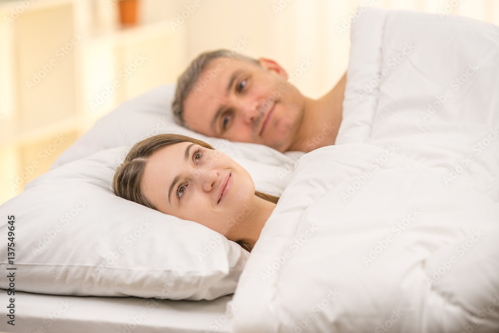 The beautiful couple lie on the bed The beautiful couple lie on the bed