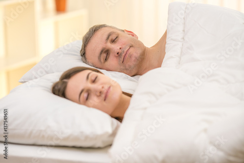 The happy couple sleeping on the bed