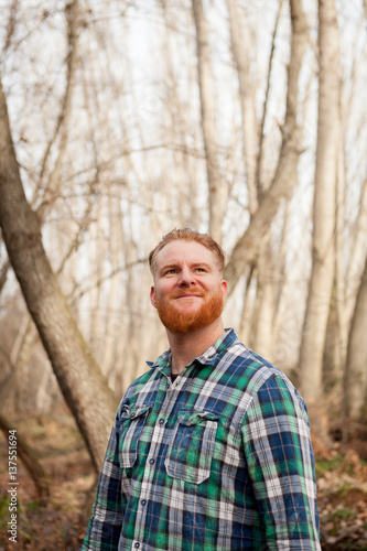 Portrait of red haired man with long beard in the forest