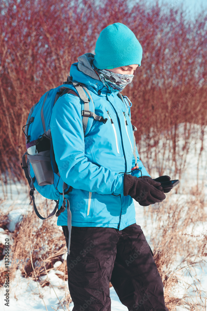 Boy using the mobile phone during the winter trip
