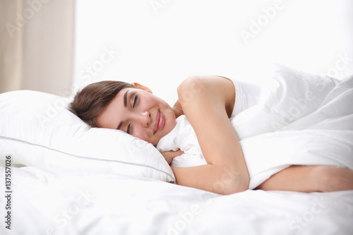 Beautiful girl sleeps in the bedroom, lying on bed