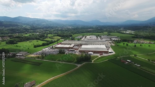 Aerial view of the factory, between meadows and mountains