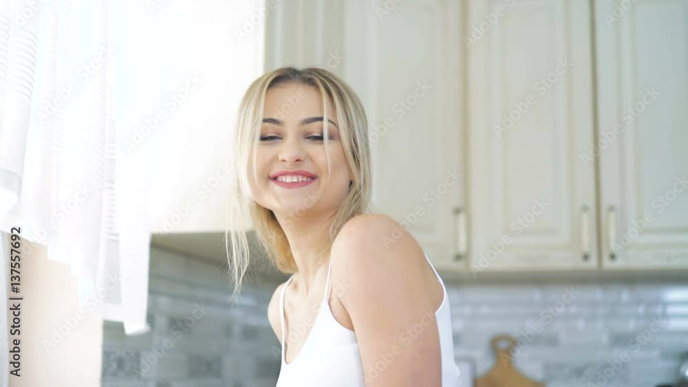 Smiling blonde tasting a spoon of honey on the kitchen in 4K Smiling blonde tasting a spoon of honey on the kitchen in 4K