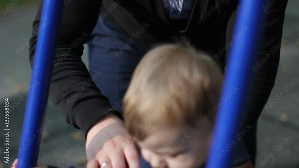 little boy riding on a swing closeup little boy riding on a swing closeup