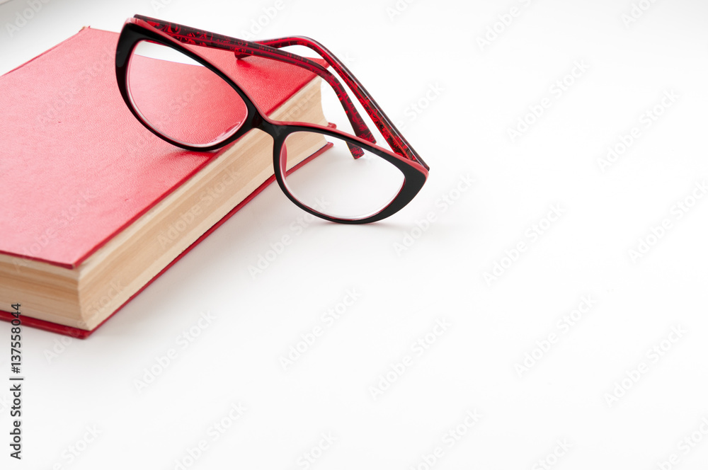 Red book and glasses on a light background Red book and glasses on a light background