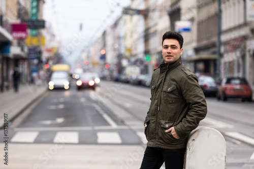 Handsome young man with olive jacket on street