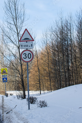 Road Sign on a winter day. Winter forest landscape behind photo