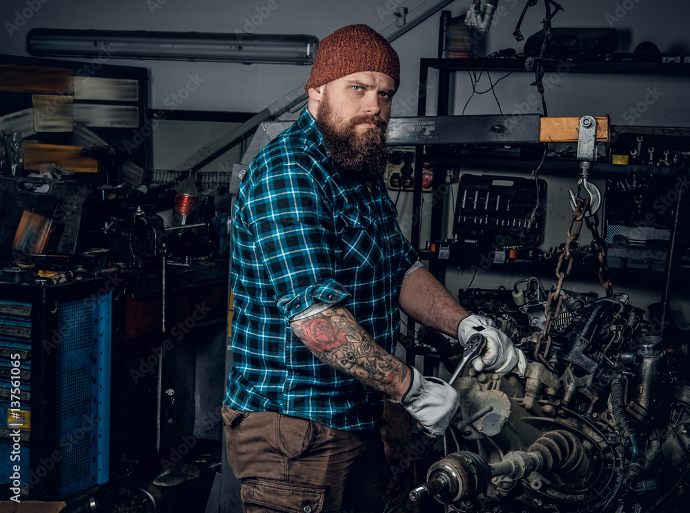 Mechanicl inspecting engine of a car in a garage. Mechanicl inspecting engine of a car in a garage.