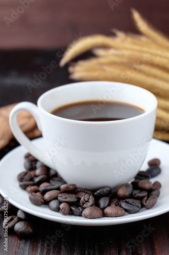 Coffee cup and coffee beans on wooden background