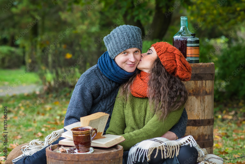loving young couple sitting in the autumn garden loving young couple sitting in the autumn garden